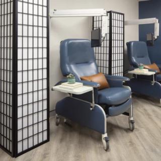 A modern healthcare setting with treatment chairs and privacy screens.