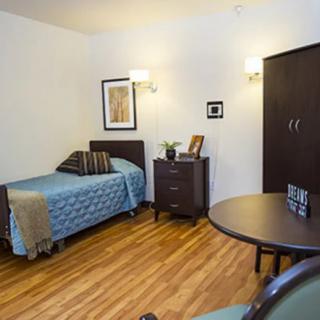 A minimalist bedroom with a single bed and modern furniture.