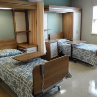 A clean and organized hospital room with two beds.