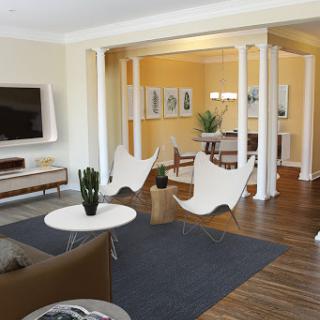 A stylish and modern living room featuring sleek furniture, an open layout, and warm color accents.