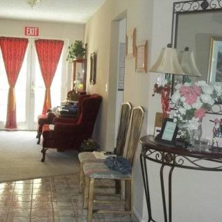 A cozy home hallway with elegant decor, featuring a mirror, chairs, and decorative curtains.