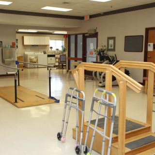 A rehabilitation clinic equipped with parallel bars and walkers for physical therapy sessions.