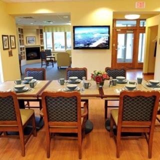 A well-decorated dining room with a set table and a view into the adjacent living area.