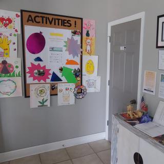 A colorful bulletin board showcasing children's artwork and activity posters in a hallway.