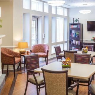 A well-lit living room with comfortable seating and tables, creating a cozy atmosphere.