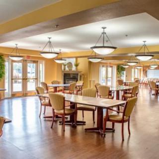 A spacious and well-lit dining area with wooden tables and chairs.