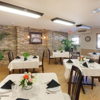 An elegant dining area with neatly arranged tables and chairs, featuring tasteful decor.