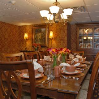 A beautifully arranged dining room featuring an elegant table setting adorned with flowers and soft lighting.