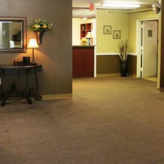 A cozy lobby area with a decorative mirror and a small table under warm lighting.