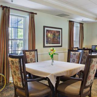 A cozy dining area with a table set for four, featuring elegant chairs and tasteful decor.