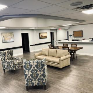 A modern waiting room with contemporary furniture and artwork on the walls.