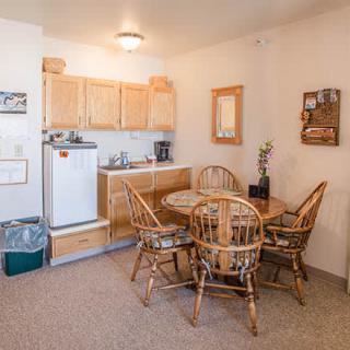 A cozy kitchen and dining area with wooden furniture and appliances.