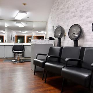A modern salon interior with chairs, hair dryers, and mirrors.