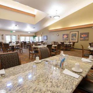 A well-lit dining area with neatly arranged tables and chairs, ready for service.