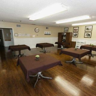 A neatly arranged meeting room with tables and chairs on a wooden floor.