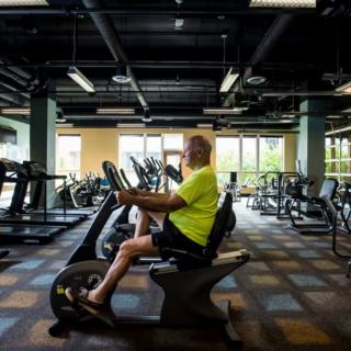 A person working out on a recumbent bike in a gym.
