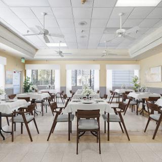 A spacious and inviting dining area featuring neatly arranged tables and chairs, perfect for casual meals or gatherings.