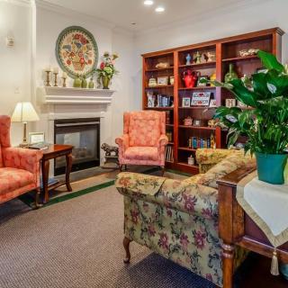 A cozy living room with a fireplace, bookshelves, and comfortable seating.