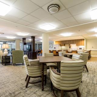 A spacious living area with comfortable seating and a kitchen in the background.