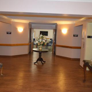 A welcoming lobby area featuring a table and chairs, illuminated by soft wall lights.
