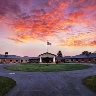 A serene view of a building against a stunning sunset backdrop, with a flag fluttering in the gentle breeze.