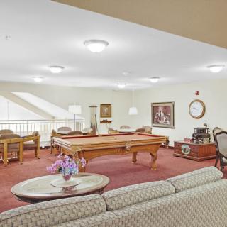 A cozy game room with a pool table, comfortable seating, and soft lighting.