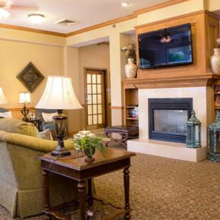 A cozy living room with a fireplace, sofa, and TV.