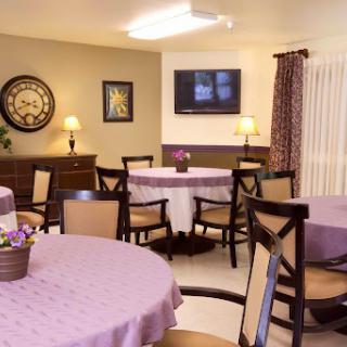 A cozy dining area featuring elegant tables and chairs, complemented by warm lighting and tasteful decor.