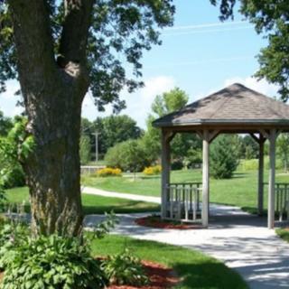 A peaceful park setting with a gazebo and lush greenery.