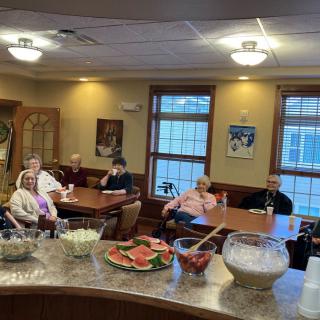 A social gathering of seniors enjoying a meal in a cozy indoor setting.