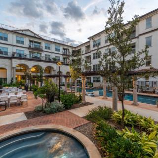 A scenic courtyard in a modern residential building with lush landscaping and outdoor seating areas.