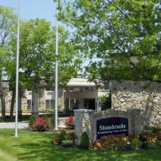 Entrance of an apartment complex with well-maintained landscaping and signage.
