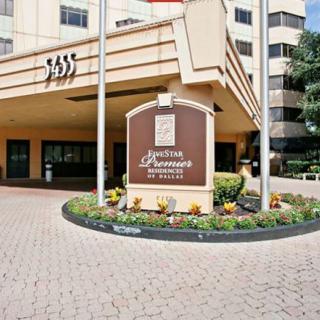 Entrance of a hotel with signage and well-maintained landscaping.