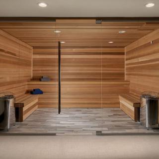 A modern wooden sauna with benches and buckets, designed for relaxation and wellness.