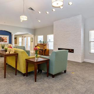 A modern living room with colorful seating and a stylish fireplace.