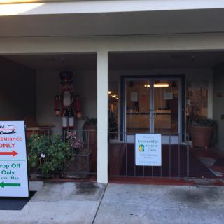 The entrance to a building with holiday decorations and directional signs.