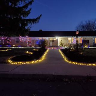 A beautifully decorated house illuminated with lights along the pathway during the evening.