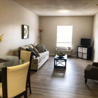 A cozy and well-furnished living room with a sofa, chairs, table, and television.
