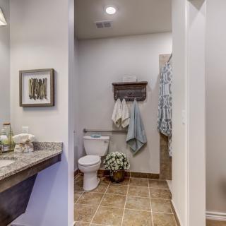 A well-organized bathroom with a toilet, sink, and hanging towels.