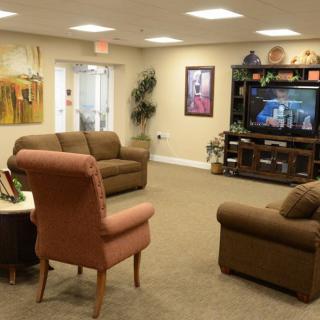 A cozy living room with sofas, an armchair, and a television.
