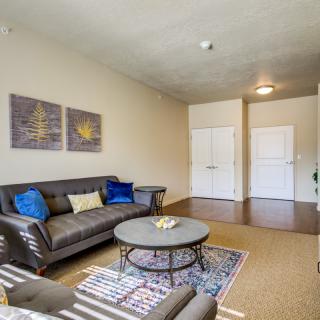 A cozy living room with a comfortable sofa, a round coffee table, and decorative artwork on the wall.