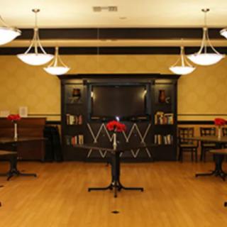 An elegant dining room with arranged tables, chairs, and warm lighting.