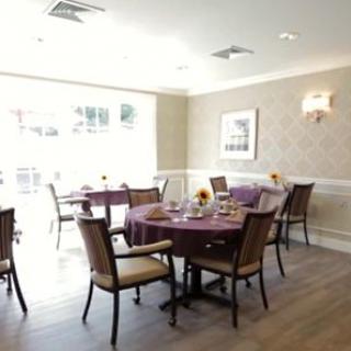 A well-lit dining room with elegantly arranged tables and chairs.