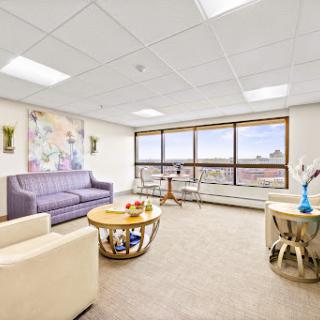 A modern office space featuring comfortable seating and a scenic city view.