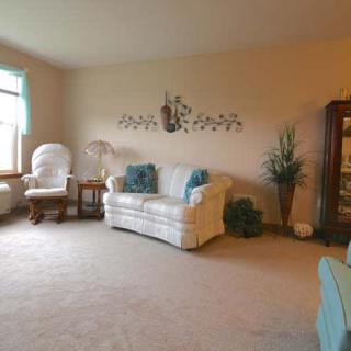 A cozy living room with a white sofa, blue cushions, and decorative elements.