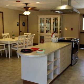 A modern kitchen with an island counter and a dining area.