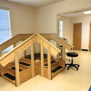 A rehabilitation facility featuring a wooden staircase structure designed for therapy sessions.