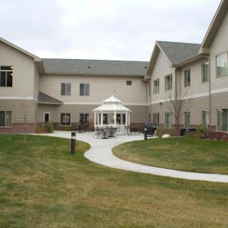 A serene courtyard featuring a gazebo surrounded by well-maintained landscaping and a pathway.