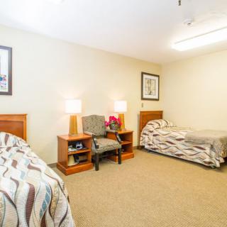 A cozy bedroom with twin beds, soft lighting, and simple decor.