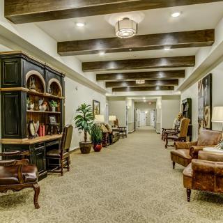 A well-decorated hallway with wooden ceiling beams and elegant furniture.